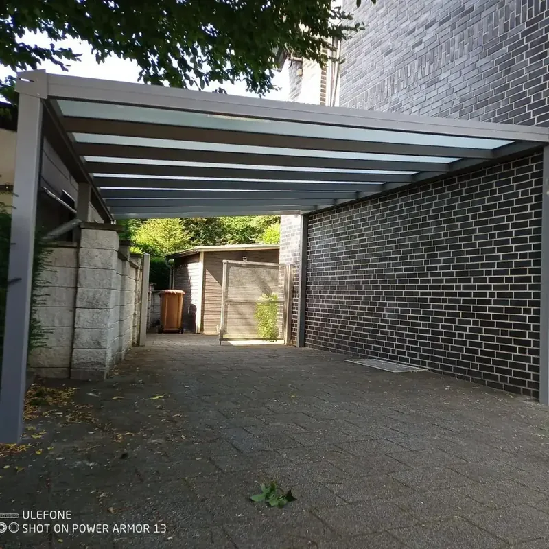 Wandseitig montierter Aluminium-Carport in Anthrazit an einer Klinkerwand