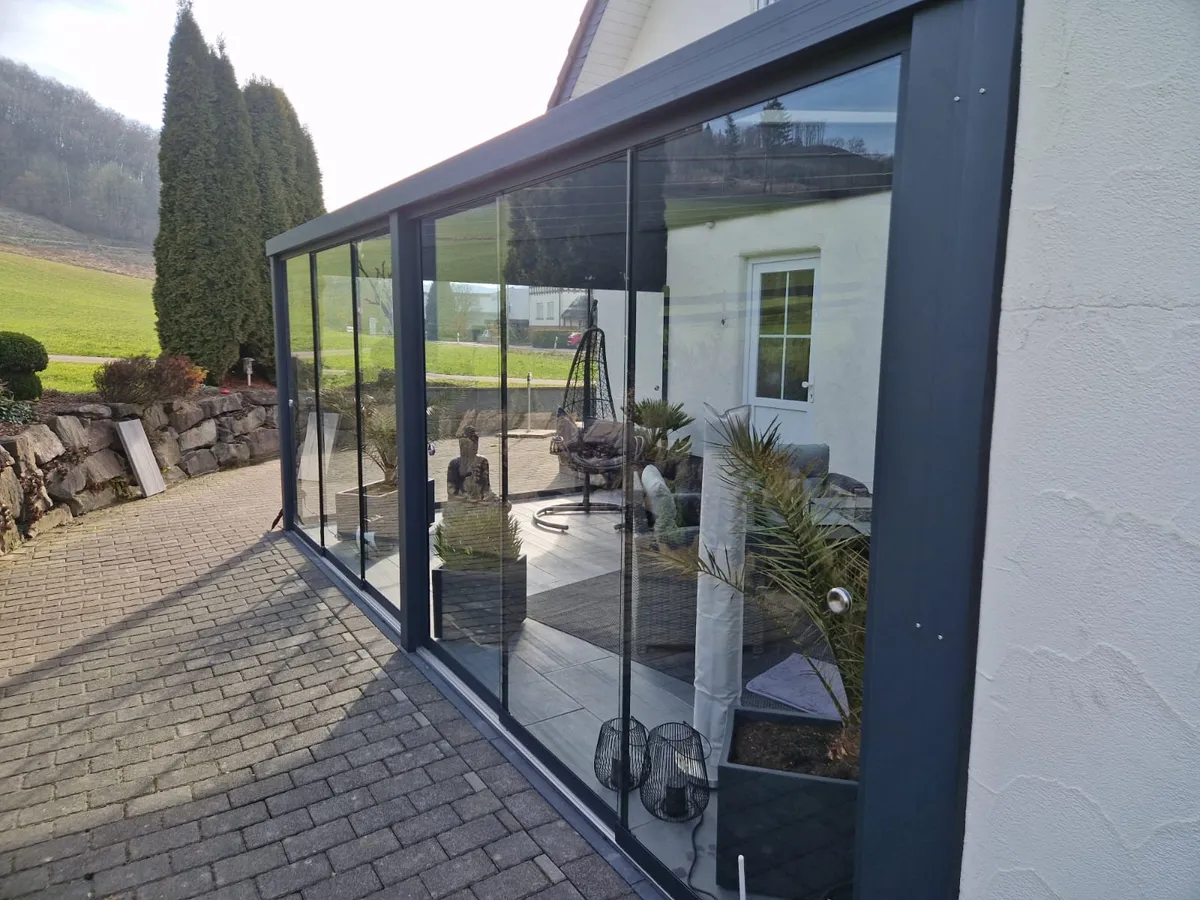 Alu Terrassenüberdachung mit Glasschiebewand in Hanglage