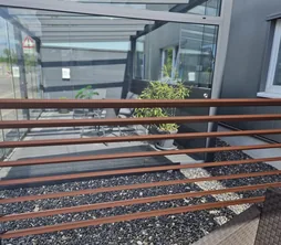 Lamellenwand in Terracotta an einer Terrassenüberdachung montiert