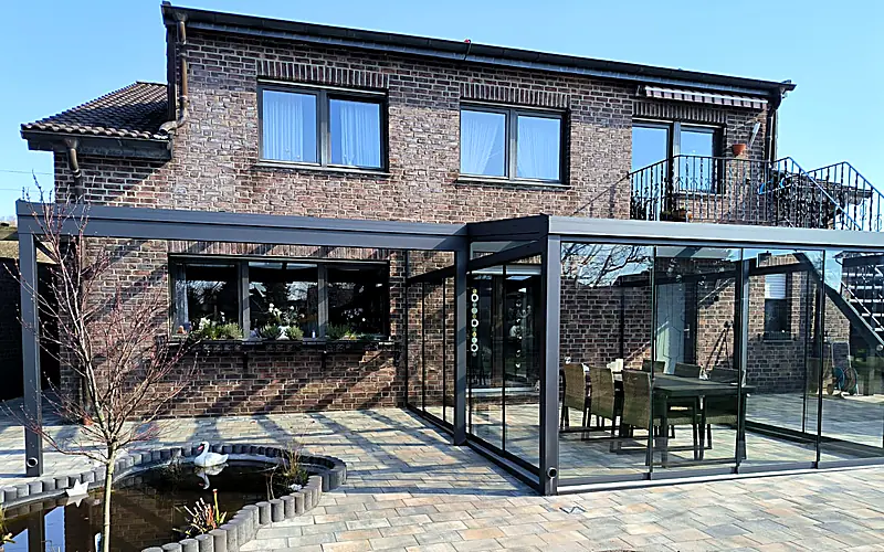 Stabile Aluminium-Konstruktion mit Glasschiebewand an einem Klinkerhaus